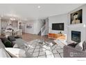 Open concept living room with fireplace, kitchen, and dining area at 1815 Chaffee Crest Dr, Berthoud, CO 80513