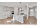 Modern kitchen with island, stainless steel appliances, and light gray cabinets at 1815 Chaffee Crest Dr, Berthoud, CO 80513