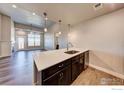 Kitchen island with white quartz countertop and dark cabinets at 265 High Point Dr # 304, Longmont, CO 80504