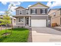 Two story home with gray siding, white trim, and a two-car garage at 6518 13Th St, Frederick, CO 80530