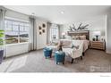 Spacious main bedroom with plush carpeting and two accent chairs at 6525 13Th St, Frederick, CO 80530