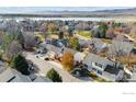 Aerial view showcasing a charming community near a lake with tree-lined streets at 3123 Concord Way, Longmont, CO 80503