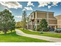 Tan multi-unit building with walkway, landscaping, and parking area at 985 Laramie Blvd # C, Boulder, CO 80304