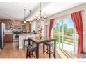 Open concept kitchen and dining area with wood flooring and breakfast bar at 12921 Grant W Cir # B, Thornton, CO 80241