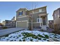 Two-story house with gray siding, a two-car garage, and a landscaped front yard with a tree at 1908 Homestead Dr, Fort Lupton, CO 80621