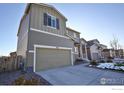 Two-story house with gray siding, a two-car garage, and a partially snow-covered driveway at 1908 Homestead Dr, Fort Lupton, CO 80621