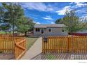 Charming ranch home with a well-manicured lawn and wood fence at 1980 Ruth Dr, Thornton, CO 80229