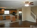 Spacious kitchen with hardwood floors, an island, stainless steel appliances, and an adjacent living room at 10695 Butte Dr, Longmont, CO 80504