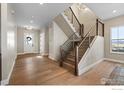 Welcoming foyer with a modern staircase, wood floors, and ample natural light at 1426 Swan Peter Dr, Berthoud, CO 80513