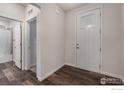 Bright foyer with dark wood flooring, leading to bathroom and storage at 14776 Longhorn Dr, Mead, CO 80542