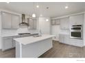 Modern kitchen with gray cabinetry, quartz countertops, and stainless steel appliances at 1829 Sawtooth Mountain Dr, Berthoud, CO 80513