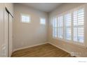 Simple bedroom with wood floors and window with shutters at 2371 Stonecrop Way, Superior, CO 80027