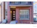 Townhouse front entrance with modern door and brick facade at 2371 Stonecrop Way, Superior, CO 80027