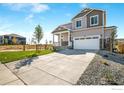 Two-story house with gray siding, white garage door, and stone accents at 4208 Sandstone Dr, Mead, CO 80504