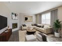 Spacious living room with corner fireplace, L-shaped sofa, and large windows at 4208 Sandstone Dr, Mead, CO 80504