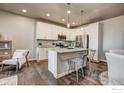 Open concept kitchen with island and hardwood floors at 410 High Point Dr # 105, Longmont, CO 80504