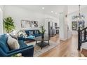 Open living room with hardwood floors, a blue couch and a view of the kitchen at 608 Bluegrass Dr, Longmont, CO 80503