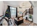 Living room with hardwood floors, large windows, and a Christmas tree at 1710 Sunlight Dr, Longmont, CO 80504