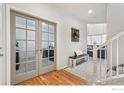 Bright entryway with hardwood floors and French doors leading to an office at 6650 Sunburst Ave, Firestone, CO 80504