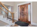 Inviting foyer with a grand wooden door, staircase, and hardwood flooring at 1490 Saint Andrews Dr, Broomfield, CO 80020