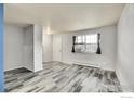 Living room with gray wood-look tile, blue accent wall, and a window AC unit at 2049 Estes Ln # 4, Longmont, CO 80501