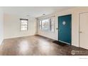 Empty living room with hardwood floors, large windows, and a teal door at 315 29Th St, Boulder, CO 80305