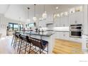 Bright, spacious kitchen featuring white cabinetry, an island with bar seating, and stainless steel appliances at 3364 Danzante Bay Ct, Berthoud, CO 80513