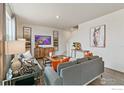 Cozy living room with plush gray couch, warm accents, and unique art at 4213 Sandstone Dr, Mead, CO 80504