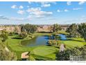 Aerial view of a golf course with a pond at 1615 Stardance Cir, Longmont, CO 80504