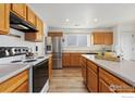 Kitchen with wooden cabinets, stainless steel appliances, and an island at 10671 Butte Dr, Longmont, CO 80504