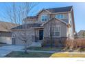 Two-story house with a beige exterior, brick accents, and a three-car garage at 1435 Rustic Dr, Longmont, CO 80504
