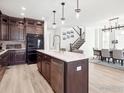 Open concept kitchen with island, stainless steel appliances, and hardwood floors at 3051 Newfound Lake Rd, Berthoud, CO 80513