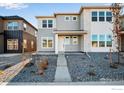 Two-story townhome with gray siding, stone accents, and a landscaped front yard at 1773 Mount Meeker Ave, Berthoud, CO 80513
