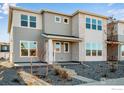 Two-story townhome with gray siding, stone accents, and a landscaped front yard at 1773 Mount Meeker Ave, Berthoud, CO 80513