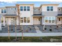 Modern two-story townhome with gray siding, stone accents, and landscaped front yard at 1777 Mount Meeker Ave, Berthoud, CO 80513