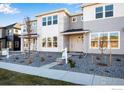 Modern two-story townhome with gray siding, stone accents, and landscaped front yard at 1777 Mount Meeker Ave, Berthoud, CO 80513