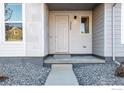 Modern front door with light gray paint and small side window at 1777 Mount Meeker Ave, Berthoud, CO 80513