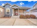 Inviting front porch with red door and brick facade at 9042 Eldorado Ave, Frederick, CO 80504