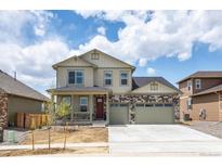 Two-story house with light beige siding, stone accents, and a two-car garage at 1815 Chaffee Crest Dr, Berthoud, CO 80513