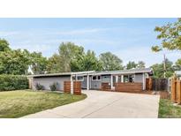 Ranch style home with modern gray exterior, landscaped yard, and attached carport at 2370 S Osceola St, Denver, CO 80219