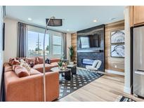 Spacious living room featuring a modern fireplace and ample natural light at 2571 W 69Th Pl, Denver, CO 80221