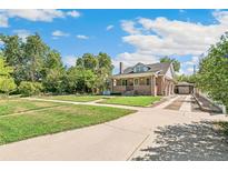 Brick house with driveway and landscaping at 1538 Oneida St, Denver, CO 80220