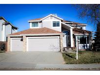 Two-story house with a three-car garage and landscaping at 9176 Sugarstone Cir, Highlands Ranch, CO 80130