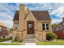 Brick house with a gabled roof, steps up to the front door and a well maintained lawn at 3734 W 26Th Ave, Denver, CO 80211