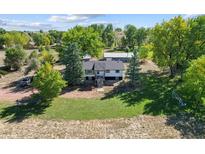Aerial view of a ranch-style home on a large lot with mature trees and outbuildings at 5142 Buffalo Rd, Erie, CO 80516