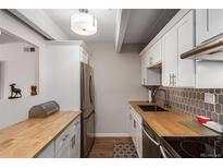 Modern kitchen with butcher block countertops and stainless steel appliances at 8060 E Girard Ave # 719, Denver, CO 80231