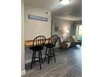 Breakfast bar with two black stools, gray walls, and wood countertop at 4899 S Dudley St # 1E, Littleton, CO 80123