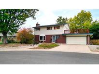 Two-story house with brick and siding, attached garage, and deck at 3384 S Elmira Ct, Denver, CO 80231