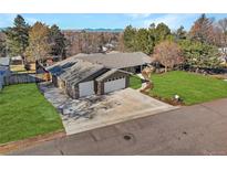 Aerial view of a house with a large yard, driveway, and mountain views at 1901 S Newport, Denver, CO 80224