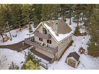 A-frame home with snowy surroundings and a deck at 30162 Pine Crest Dr, Evergreen, CO 80439